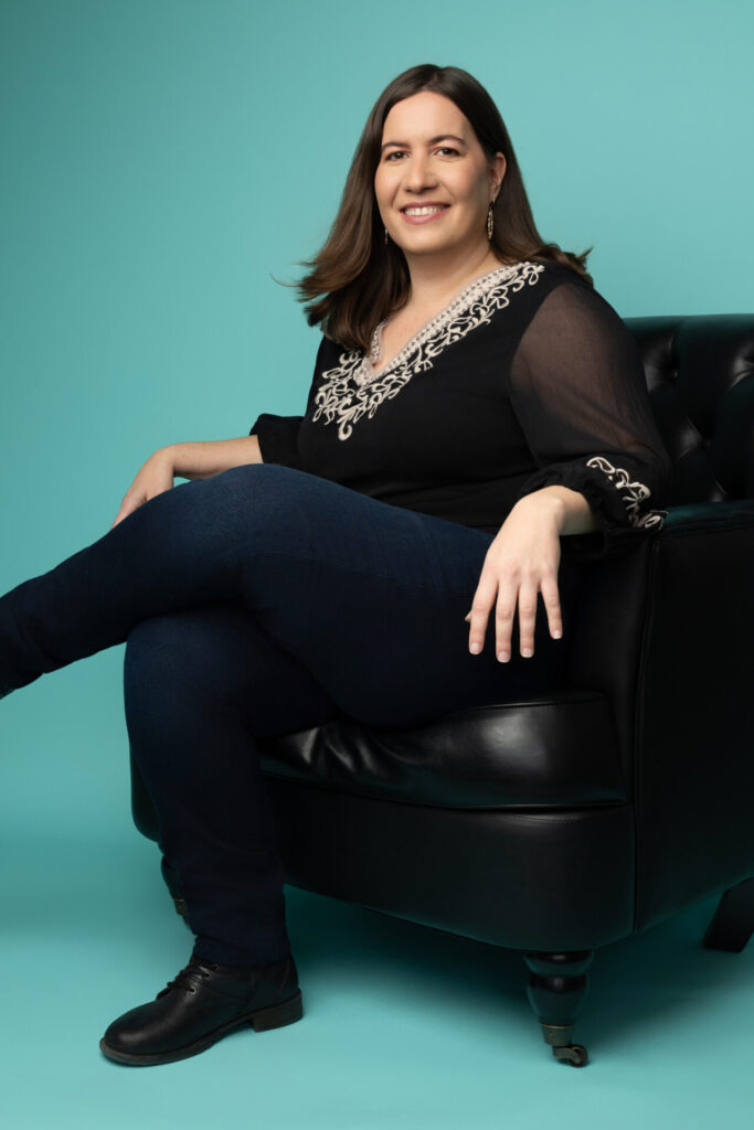 photo of Steph sitting in a chair, legs crossed